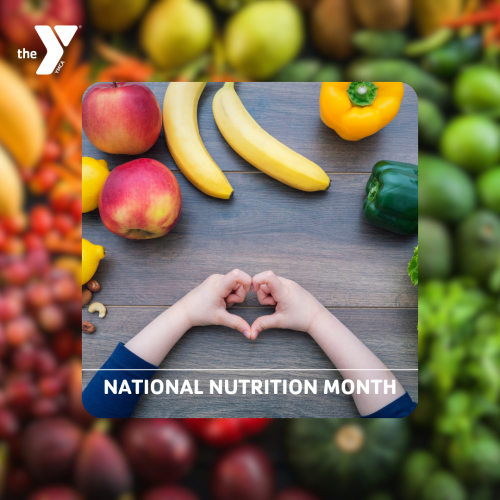 Fruits and Veggies on a table with someone holding their hands in the shape of a heart and the text "National Nutrition Month"