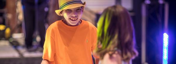 Challenger Athlete Ayden is all smiles on the dance floor at the end of the fashion show 
